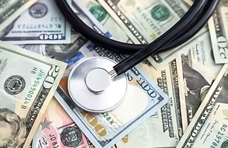 Stethoscope on scattered US dollar bills.